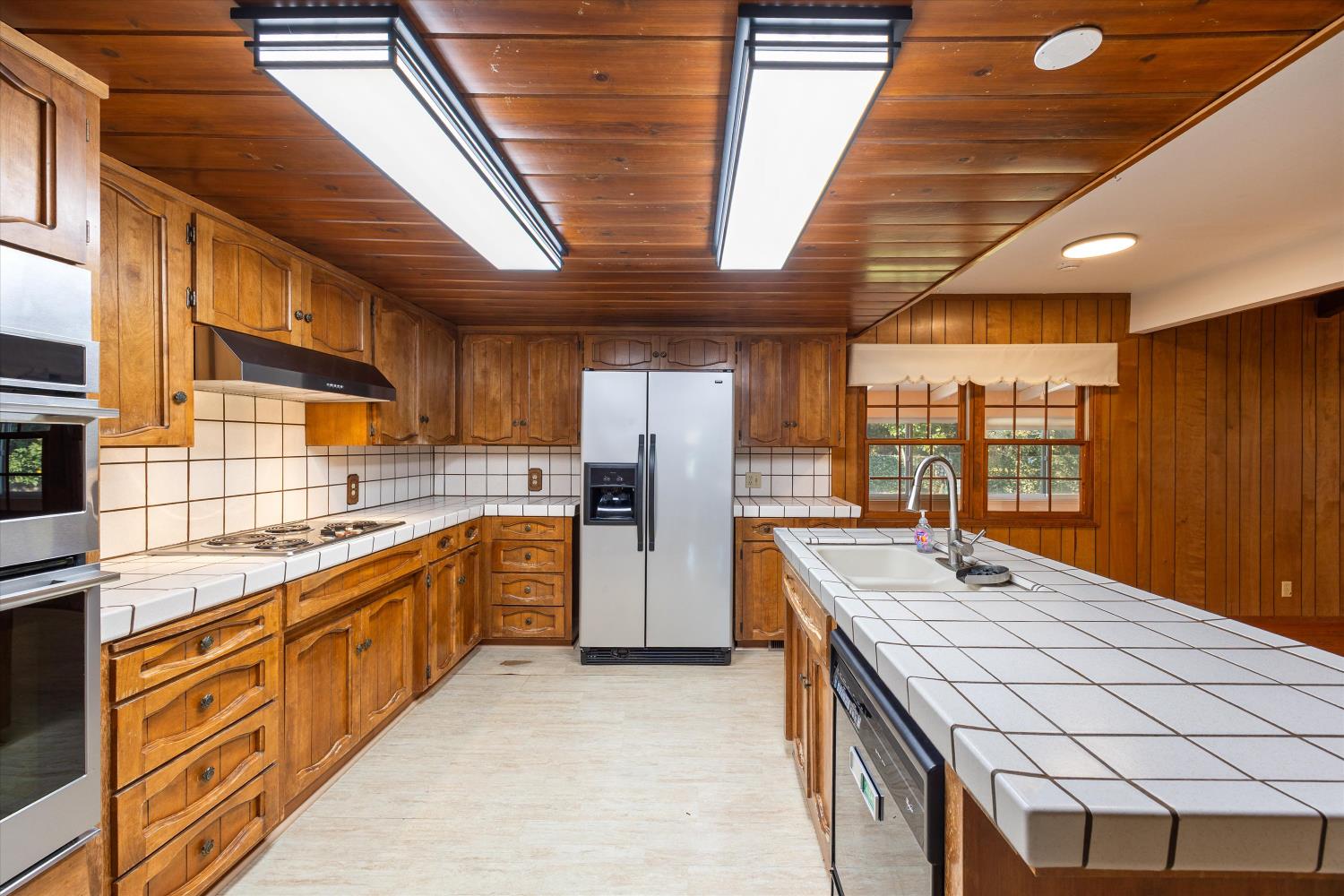1786 Le Bec Court Lodi, CA 95240 - Photo 23 of 65 a large kitchen with stainless steel appliances kitchen island granite countertop a sink and wooden cabinets