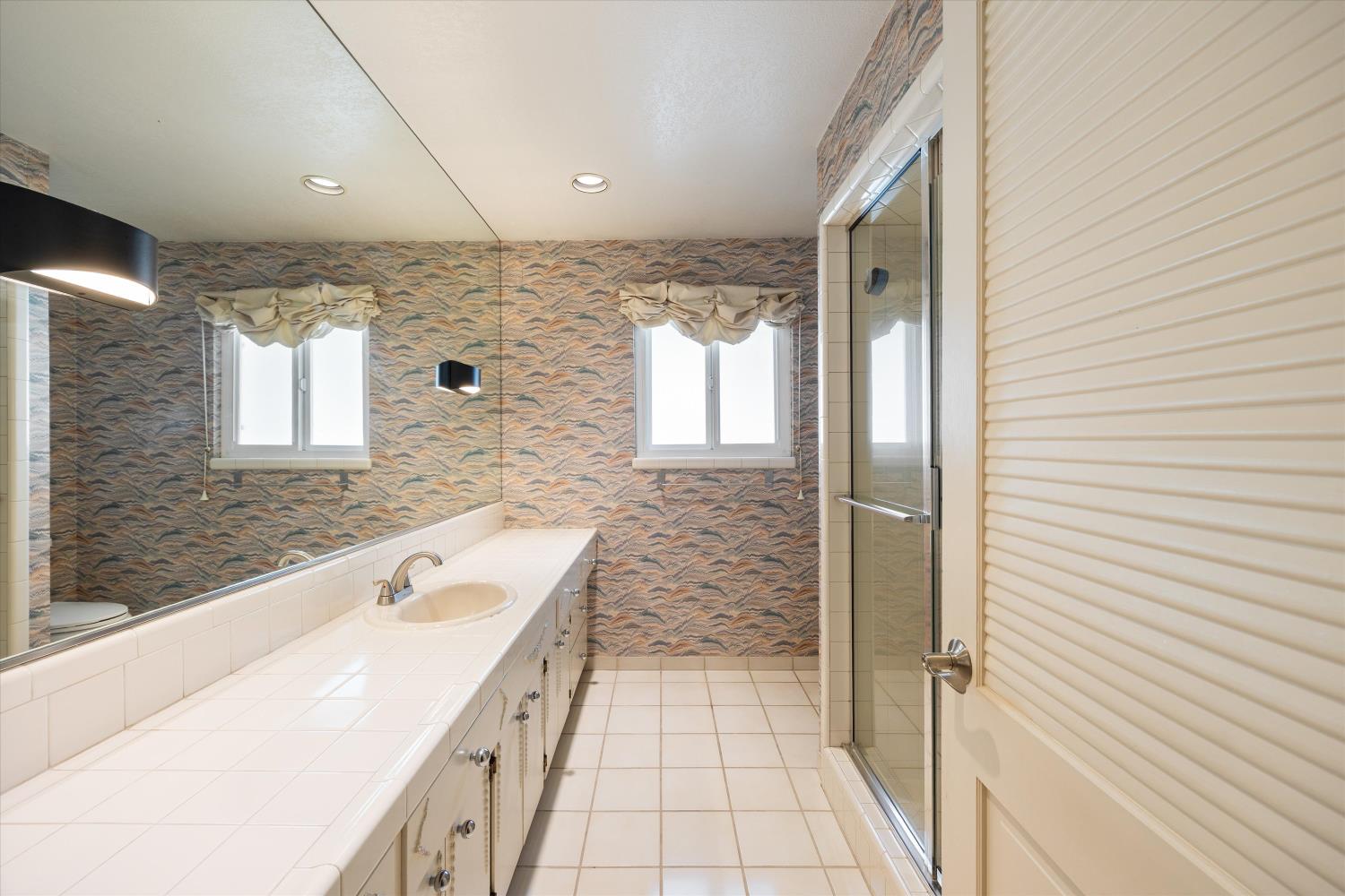 1786 Le Bec Court Lodi, CA 95240 - Photo 35 of 65 a bathroom with a tub a sink and a large mirror