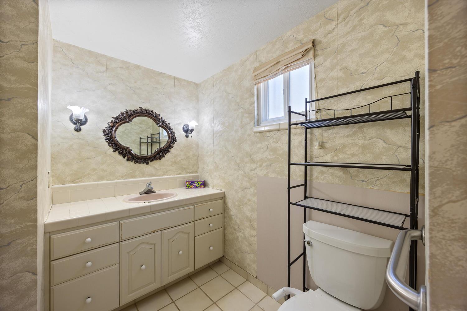 1786 Le Bec Court Lodi, CA 95240 - Photo 42 of 65 a bathroom with a toilet sink and mirror