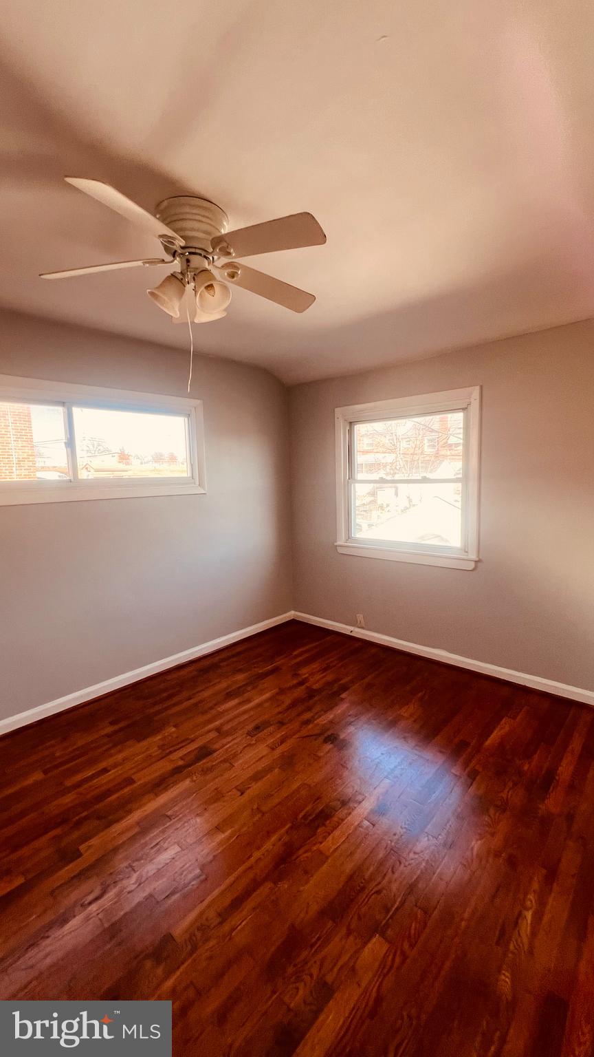 4413 Fenor Road Halethorpe, MD 21227 - Photo 18 of 31 an empty room with wooden floor fan and windows