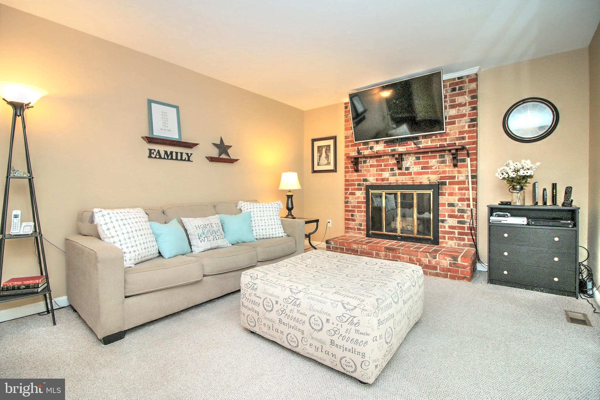 7118 Sontag Way Springfield, VA 22153 - Photo 3 of 36 a living room with furniture a flat screen tv and a fireplace