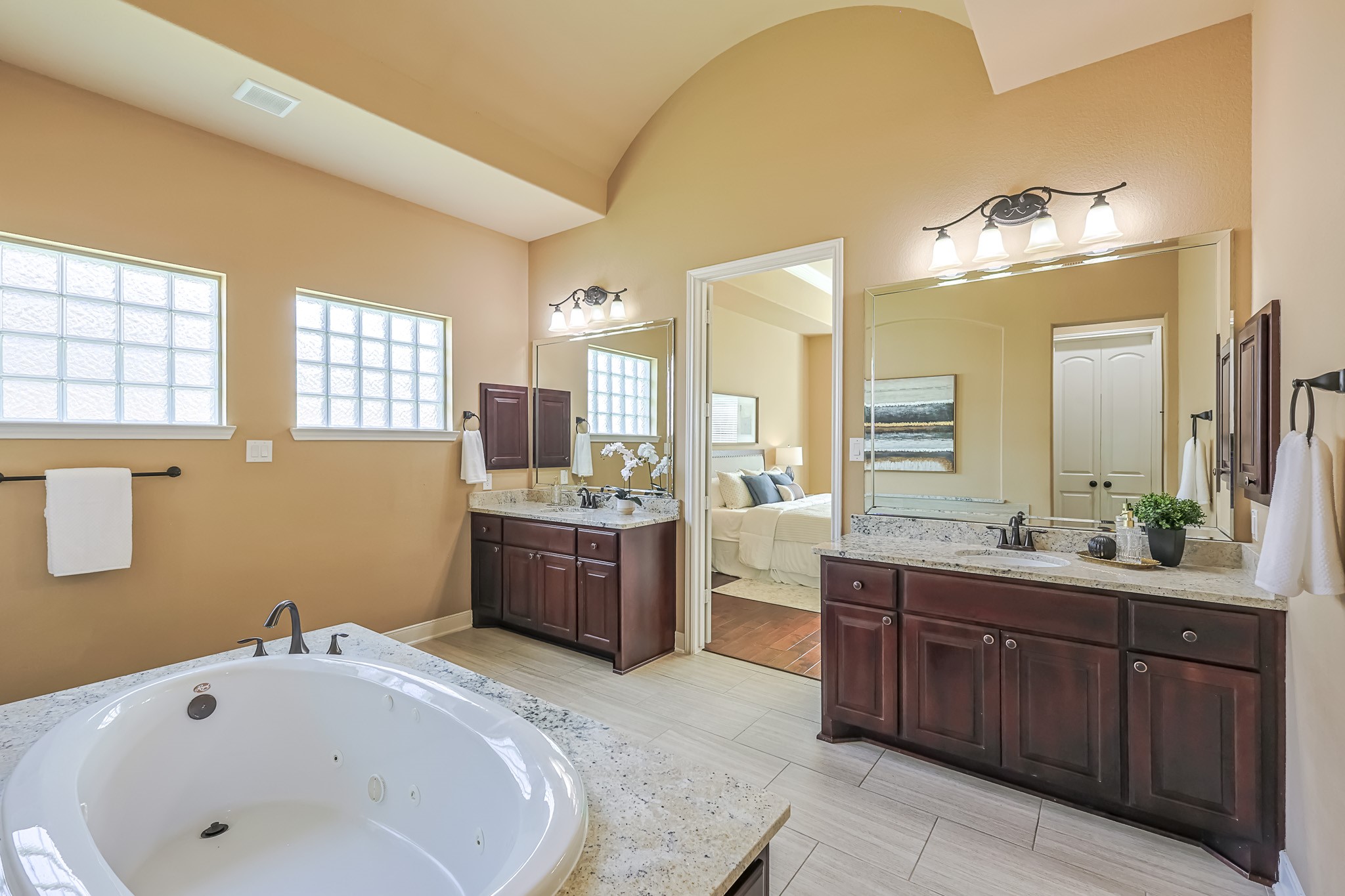 515 Mill Creek Road Pinehurst, TX 77362 - Photo 28 of 48 This spacious bathroom features dual sinks with granite countertops, a large soaking tub, and elegant wooden cabinetry.