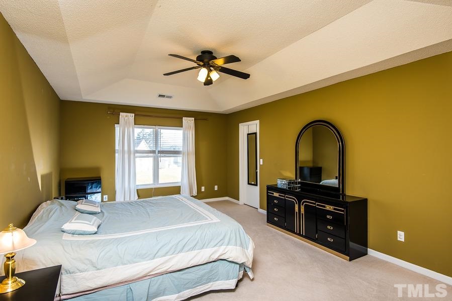 2643 Quarry Springs Road Raleigh, NC 27610 - Photo 12 of 19 a bedroom with a bed and a chandelier