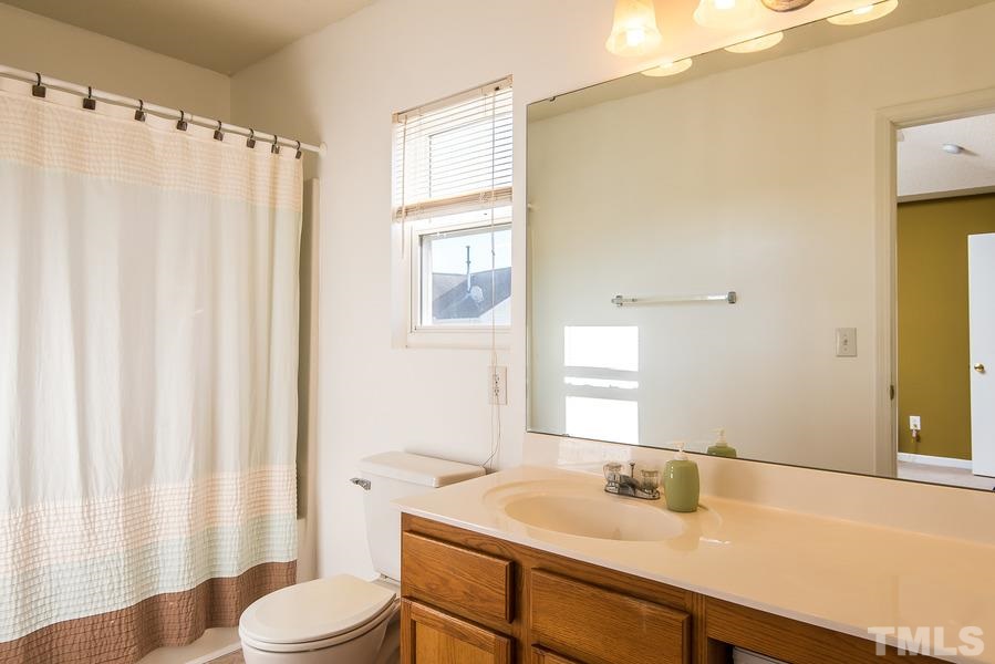 2643 Quarry Springs Road Raleigh, NC 27610 - Photo 13 of 19 a bathroom with a sink a toilet and a mirror