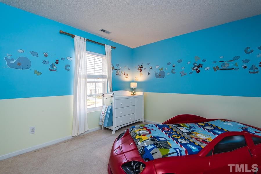 2643 Quarry Springs Road Raleigh, NC 27610 - Photo 14 of 19 a bedroom with a bed and a dresser in it