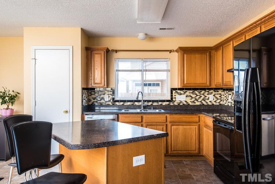 2643 Quarry Springs Road Raleigh, NC 27610 - Photo 5 of 19 a kitchen with stainless steel appliances granite countertop a sink stove and refrigerator