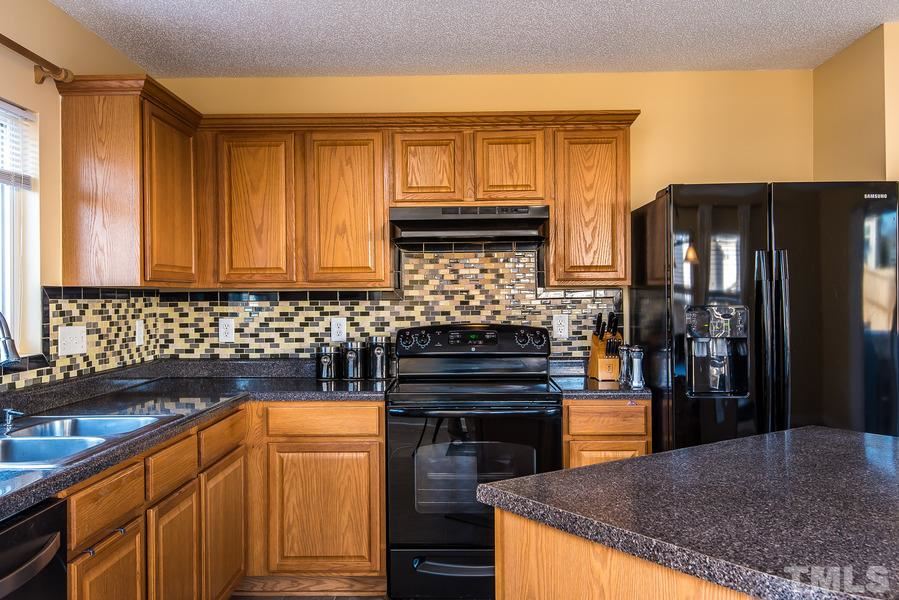 2643 Quarry Springs Road Raleigh, NC 27610 - Photo 6 of 19 a kitchen with stainless steel appliances granite countertop a sink stove and refrigerator