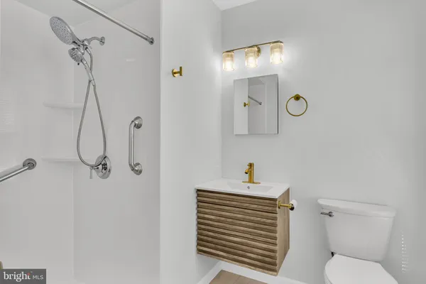 a bathroom with a sink a toilet and shower