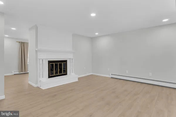 a view of an empty room with a fireplace and a window