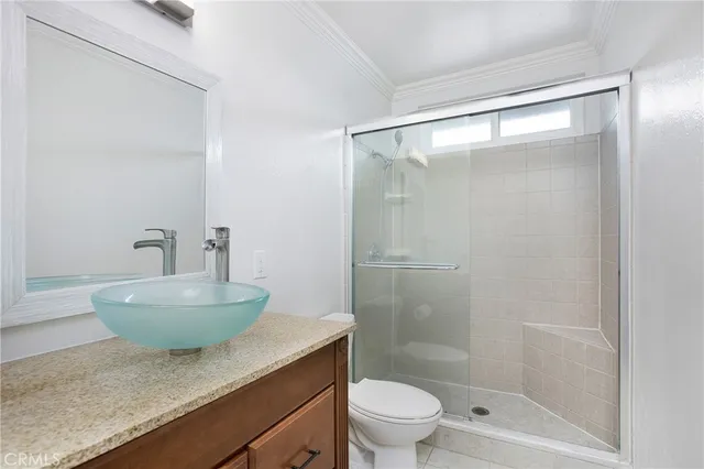 a bathroom with a granite countertop sink a toilet a mirror and a shower