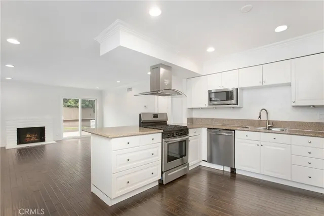 a kitchen with stainless steel appliances granite countertop a stove a sink and a refrigerator