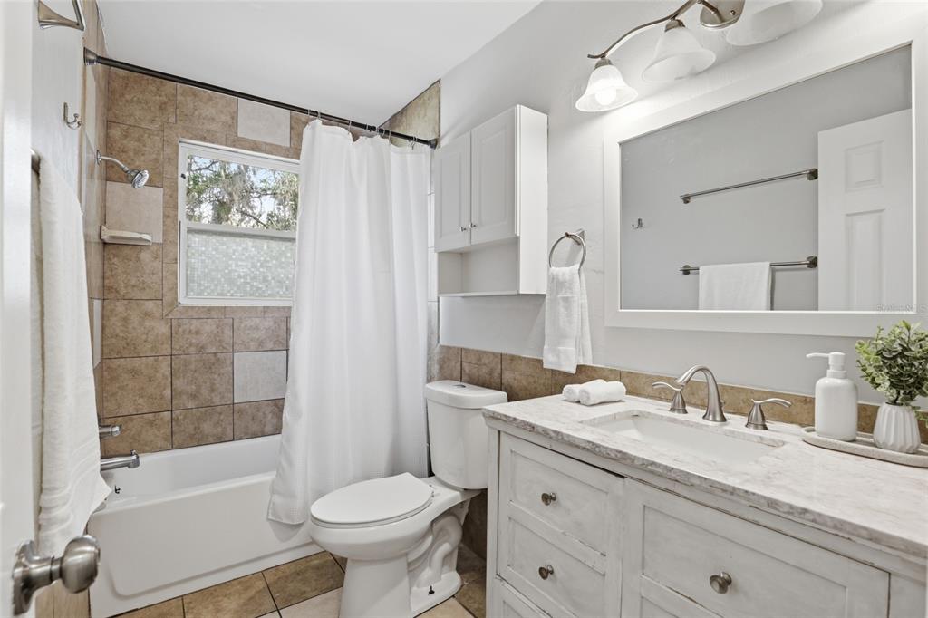 3921 Southeast 14th Terrace Gainesville, FL 32641 - Photo 24 of 32 a bathroom with a granite countertop sink toilet and shower