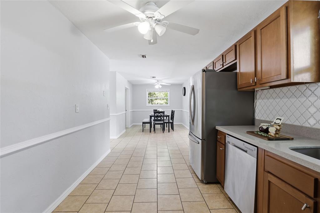 3921 Southeast 14th Terrace Gainesville, FL 32641 - Photo 10 of 32 a kitchen with granite countertop a refrigerator a sink a stove and cabinets