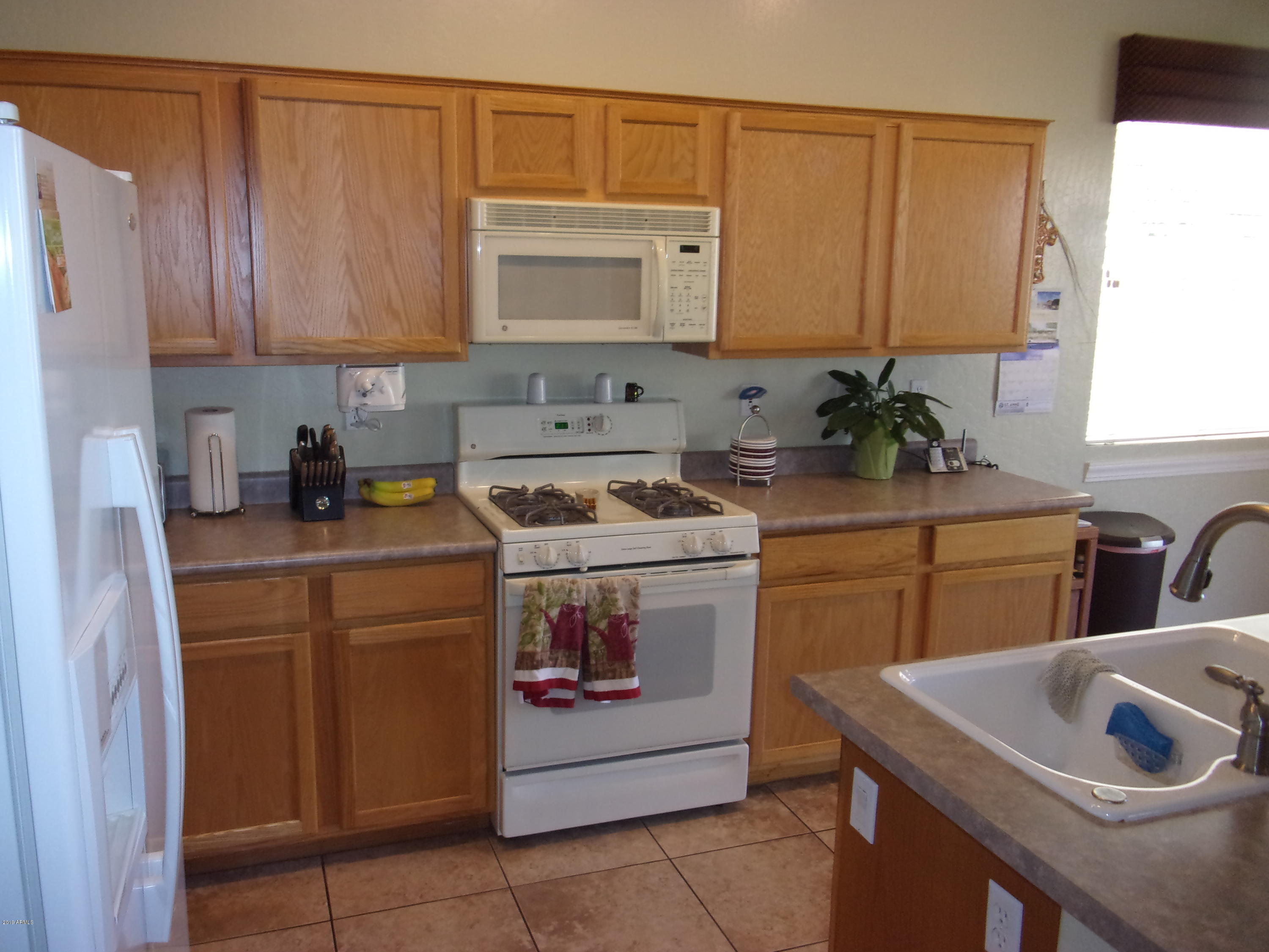 2742 East Harwell Road Gilbert, AZ 85234 - Photo 18 of 45 a kitchen with stainless steel appliances granite countertop a sink stove and cabinets