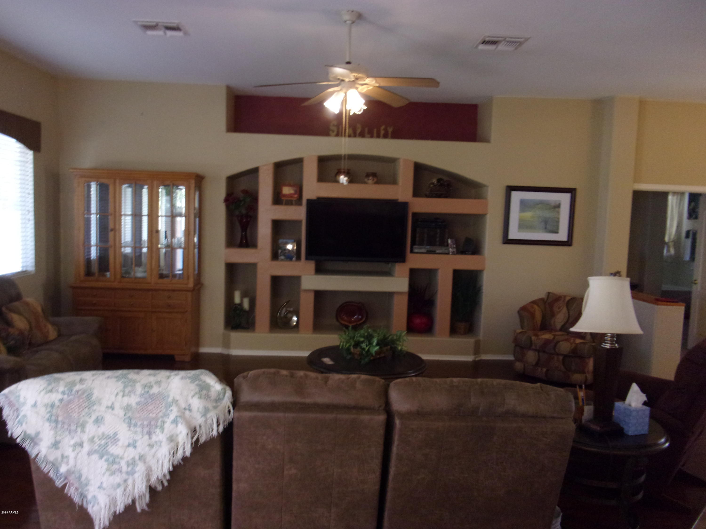 2742 East Harwell Road Gilbert, AZ 85234 - Photo 4 of 45 a living room with furniture a lamp and a fireplace