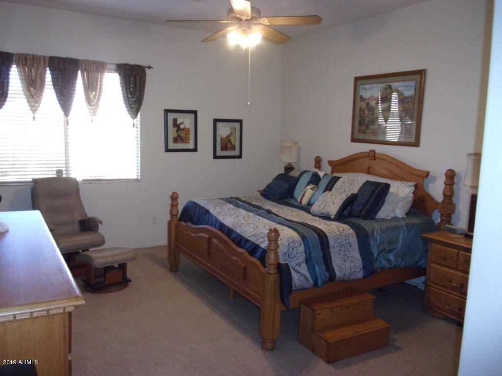 2742 East Harwell Road Gilbert, AZ 85234 - Photo 8 of 45 a bedroom with a bed and a chandelier
