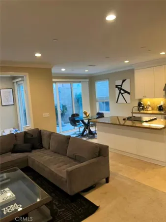 a living room with stainless steel appliances kitchen island granite countertop furniture and a wooden floor
