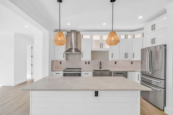 a kitchen with stainless steel appliances granite countertop a sink a stove a refrigerator and center island