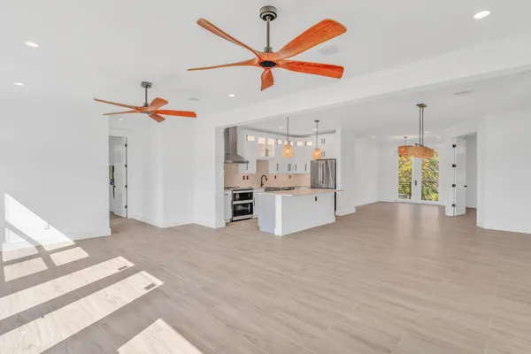 a view of a kitchen with wooden floor and a ceiling fan