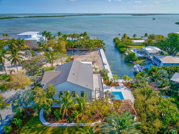 an aerial view of a house with a garden and lake view