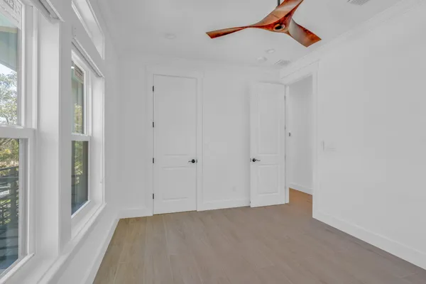 an empty room with a window and a ceiling fan