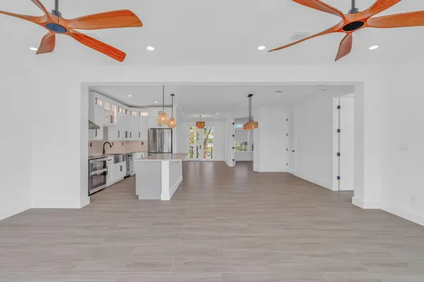 a view of a kitchen with wooden floor and a ceiling fan