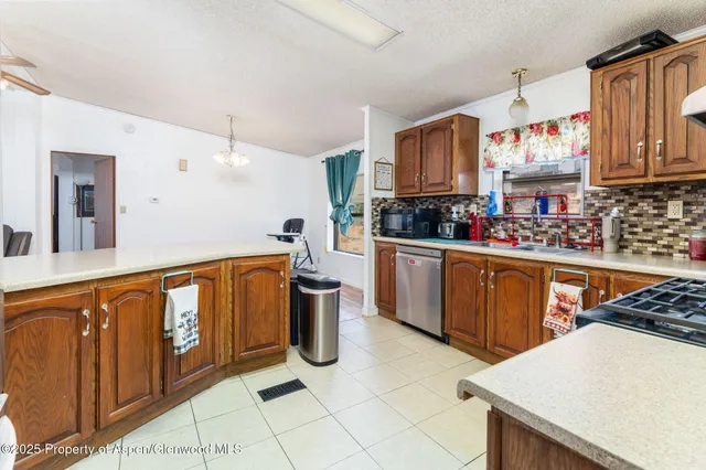 a kitchen with stainless steel appliances granite countertop a stove a sink dishwasher and a refrigerator