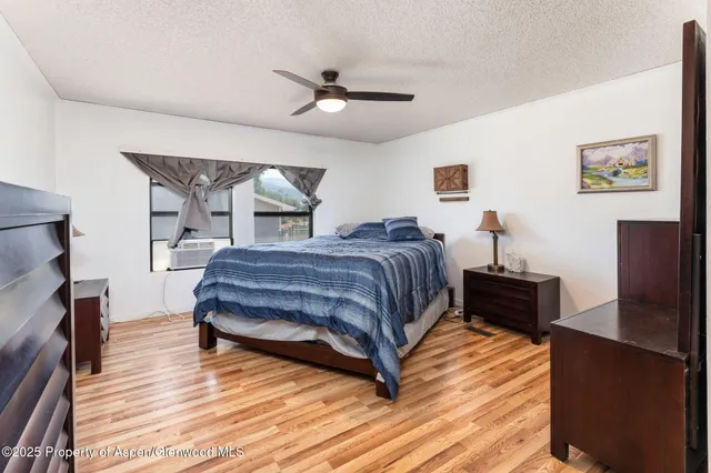 a bedroom with a bed wooden floor and window