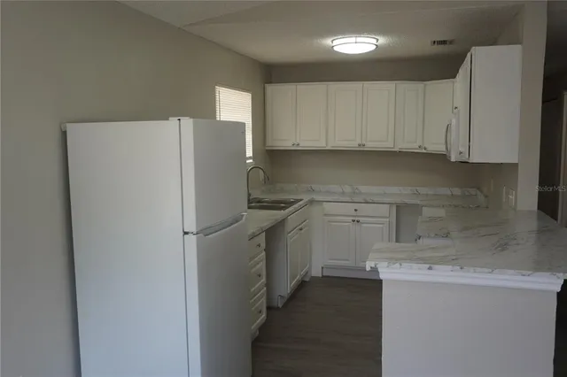a kitchen with a refrigerator sink and cabinets