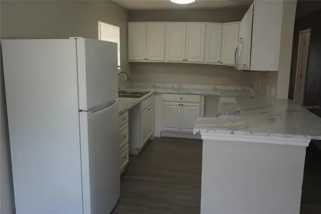 a kitchen with a refrigerator sink and cabinets