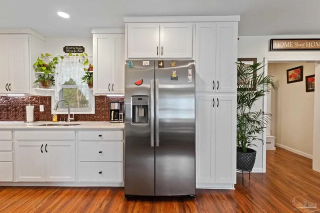a view of a hallway with wooden floor and closet