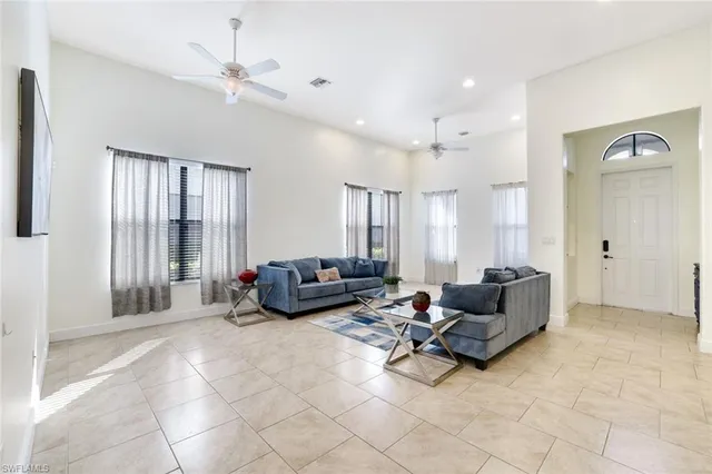 a living room with furniture and large windows