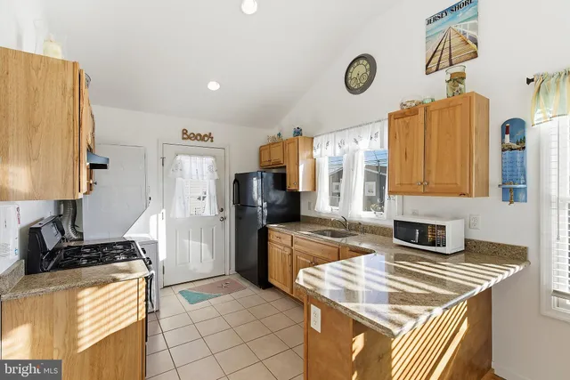 a kitchen with granite countertop a sink stove and refrigerator