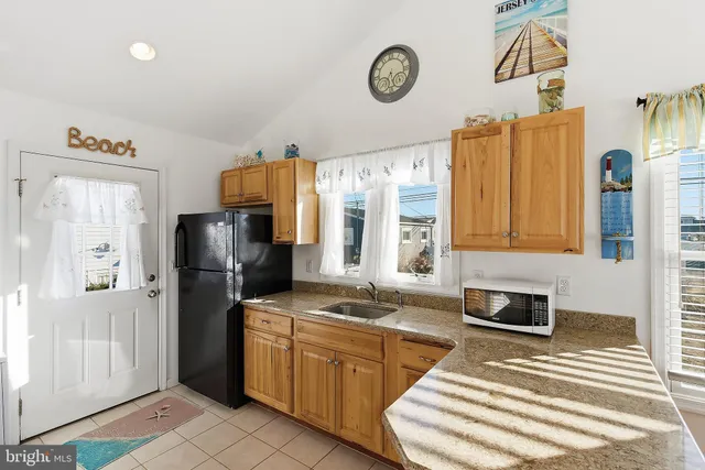 a kitchen with stainless steel appliances granite countertop a refrigerator a stove and a sink