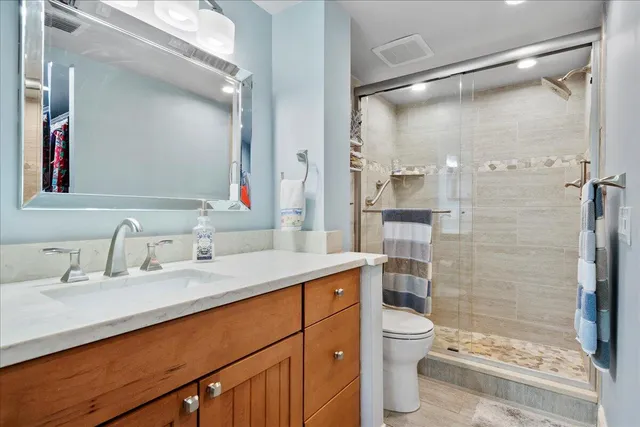 a bathroom with a sink toilet double vanity and shower