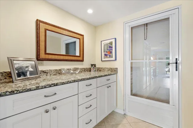 a bathroom with a granite countertop sink mirror and bathtub