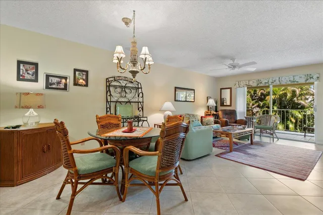 a view of a dining room with furniture a rug and a chandelier