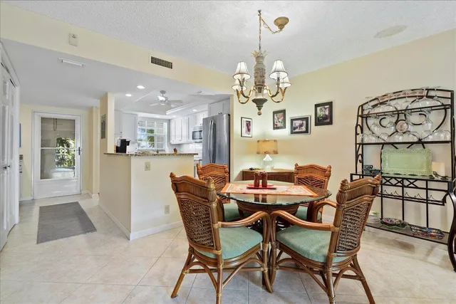 a view of a dining room and livingroom with furniture a chandelier and wooden floor