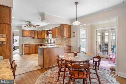 a kitchen with stainless steel appliances granite countertop a dining table chairs and a refrigerator