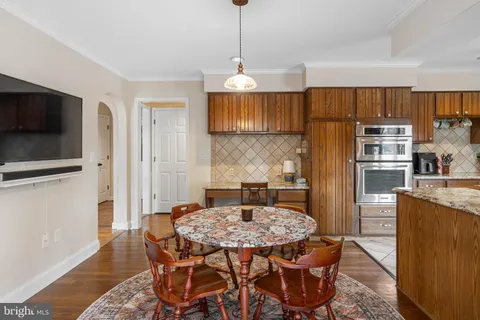 a kitchen with stainless steel appliances kitchen island granite countertop a refrigerator stove and sink