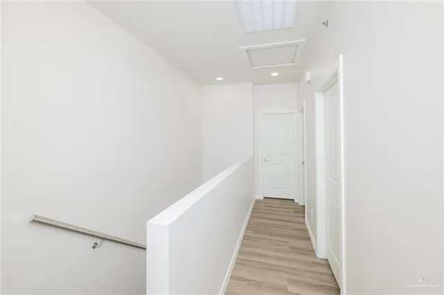 a view of a hallway with wooden floor and staircase