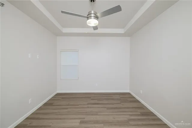 a view of an empty room with wooden floor