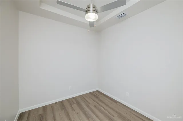a view of a room with wooden floor and fan