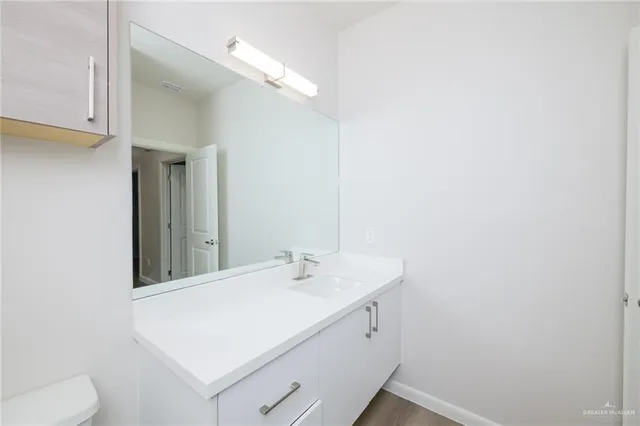 a bathroom with a sink a toilet and mirror