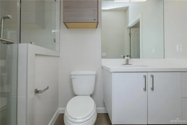 a bathroom with a toilet sink vanity and mirror