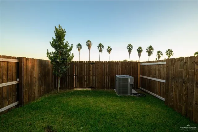 a view of a backyard with wooden fence and plants