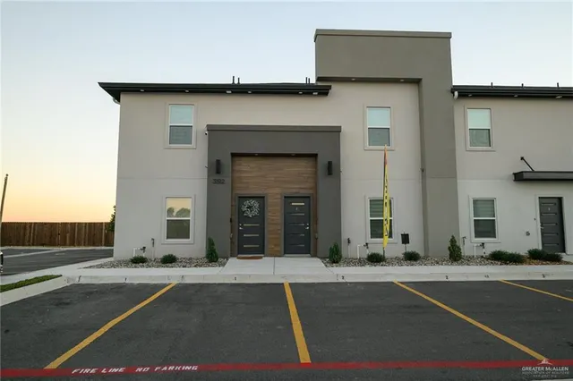 a view of a building with car parked on road