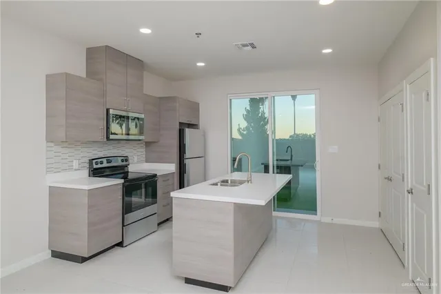 a kitchen that has a sink a stove and a refrigerator
