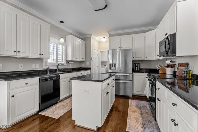 a kitchen with stainless steel appliances granite countertop a stove a sink and a refrigerator