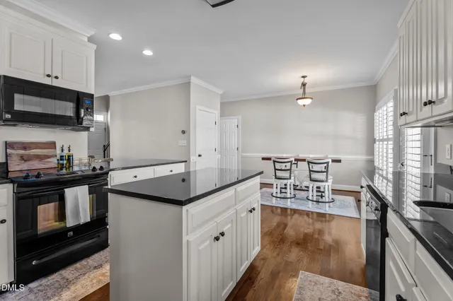 a kitchen with stainless steel appliances granite countertop a stove top oven a sink and a microwave